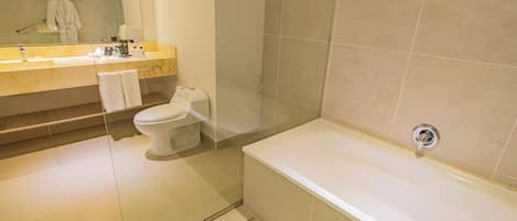 Une salle de bain moderne avec une grande baignoire, des toilettes et un meuble-lavabo avec un miroir.