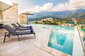 A rooftop pool with lounge chairs and a mountain view. - Sonesta Hotel Ibague (Ibagué)