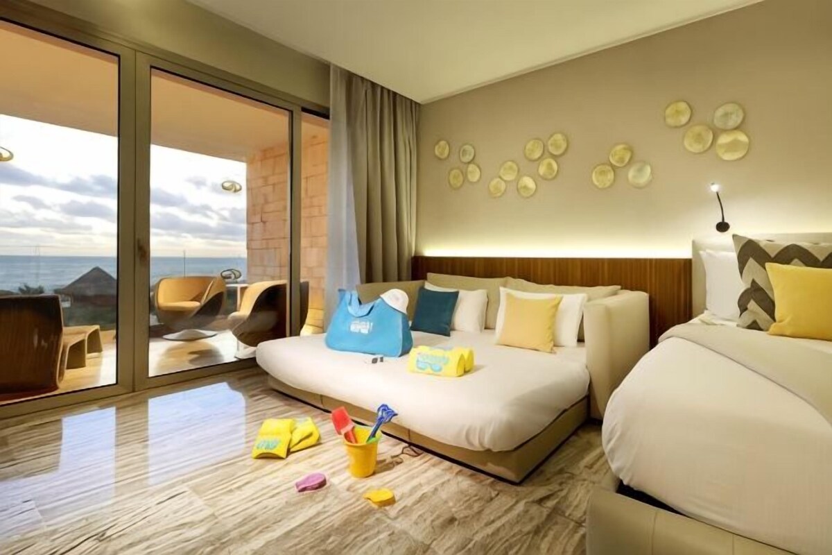 Una habitación de hotel con una cama grande, un balcón con vistas y un diseño moderno.