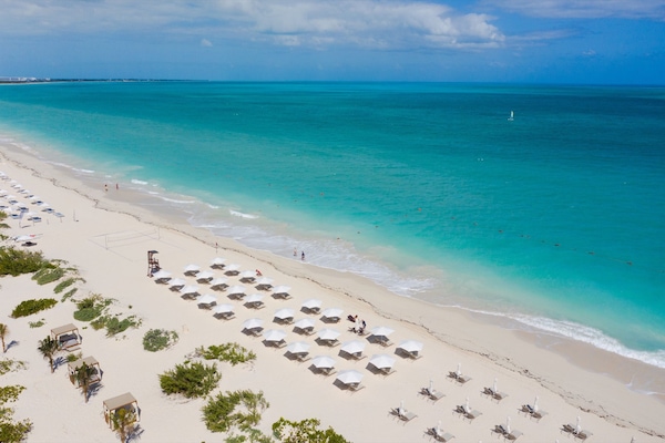 On the beach, white sand, sun-loungers, beach umbrellas