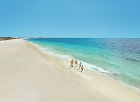 On the beach, white sand, sun loungers, beach umbrellas