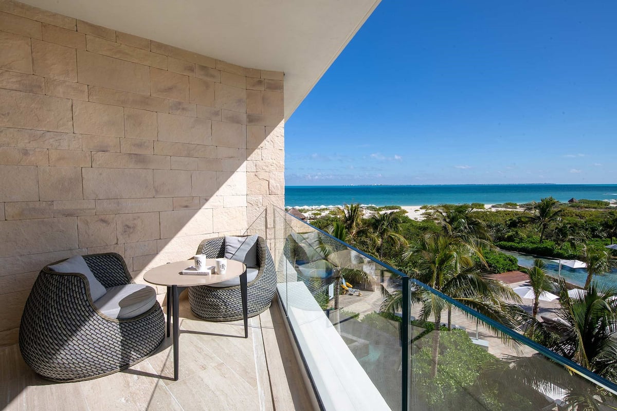 A balcony with a view of the ocean and resort amenities.
