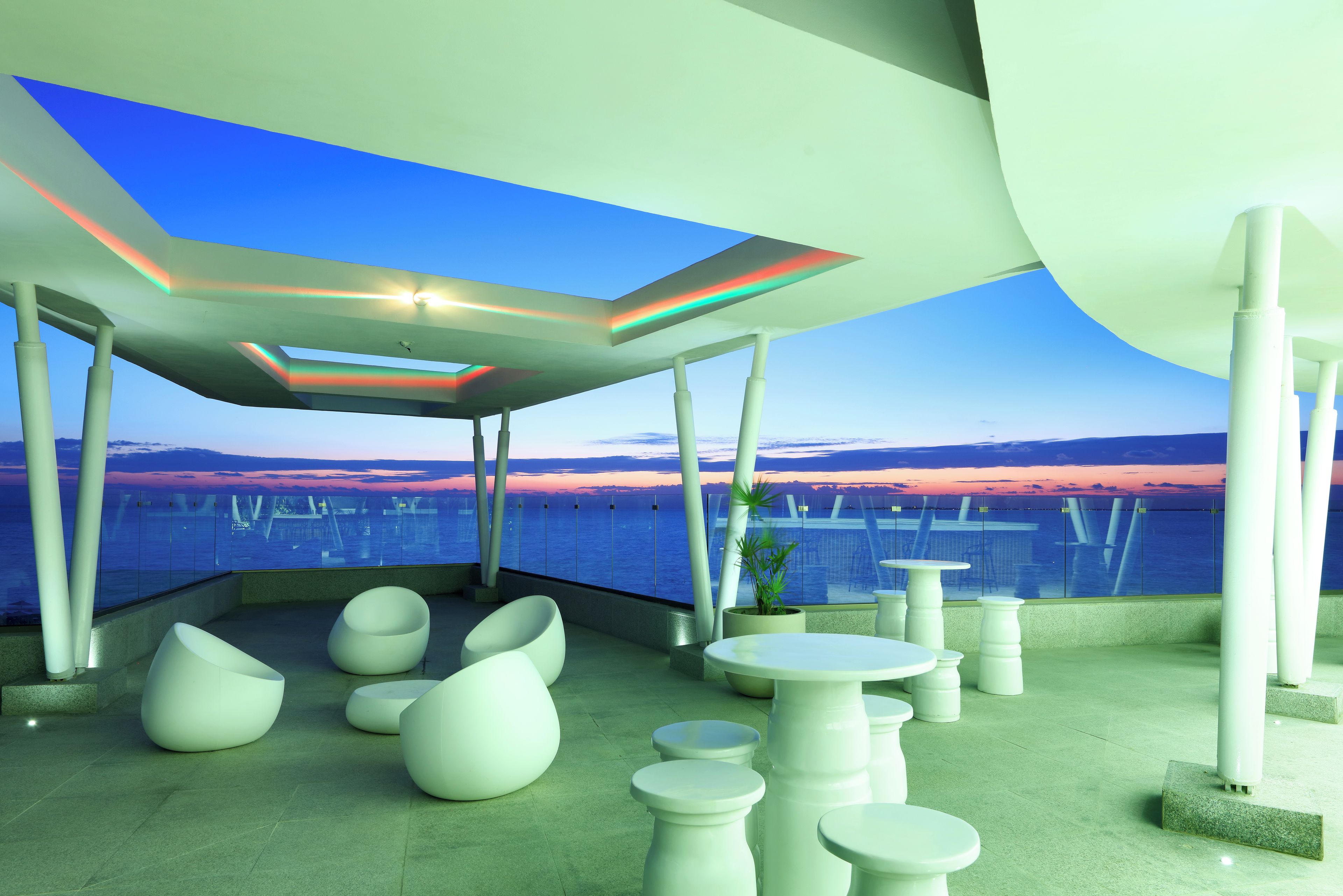 Un espace extérieur moderne, aménagé pour se détendre, avec vue sur la mer et les couchers de soleil.