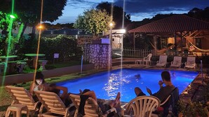 A poolside area with lounge chairs and a stone wall. - Bonito Hi Hostel e Pousada (Bonito)
