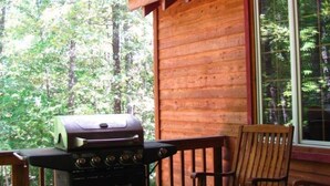 A wooden cabin with a balcony, a ceiling fan, a grill, and a rocking chair. - The Preserve, Craftsman Special Vacation Home (Fall Creek Falls)