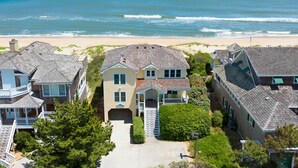 Una casa frente al mar con un porche delantero, un garaje y vistas al océano.