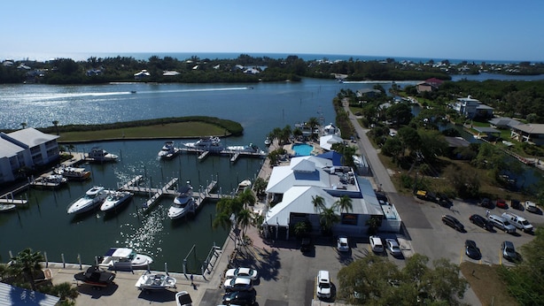 A marina with boats docked, a swimming pool, and a parking area.