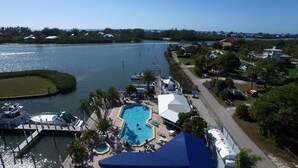 A resort with a swimming pool, docked boats, and a view of the water.