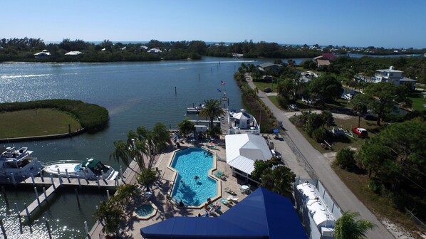 A resort with a swimming pool, docked boats, and a view of the water.