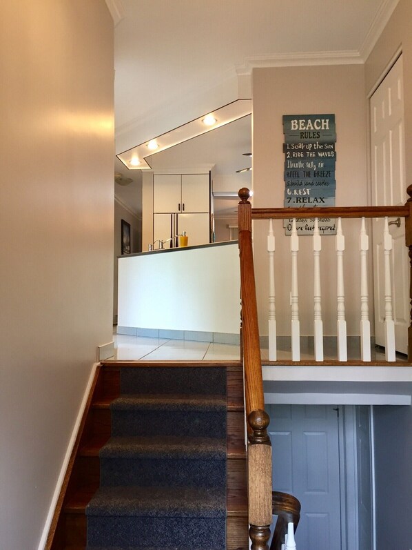 A staircase with a wooden handrail leading to a landing. A sign on the landing reads "BEACH RULES" with a list of rules. - Gorgian Bay cottage for rent in Tiny (Tiny)