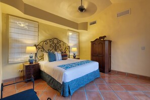 A bedroom with a bed, nightstands, a wardrobe, and a ceiling fan.