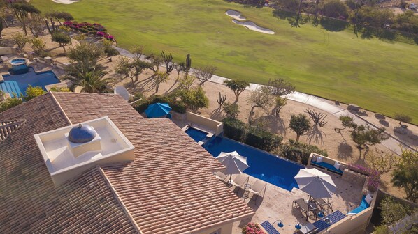 A rooftop pool with a view of a golf course.