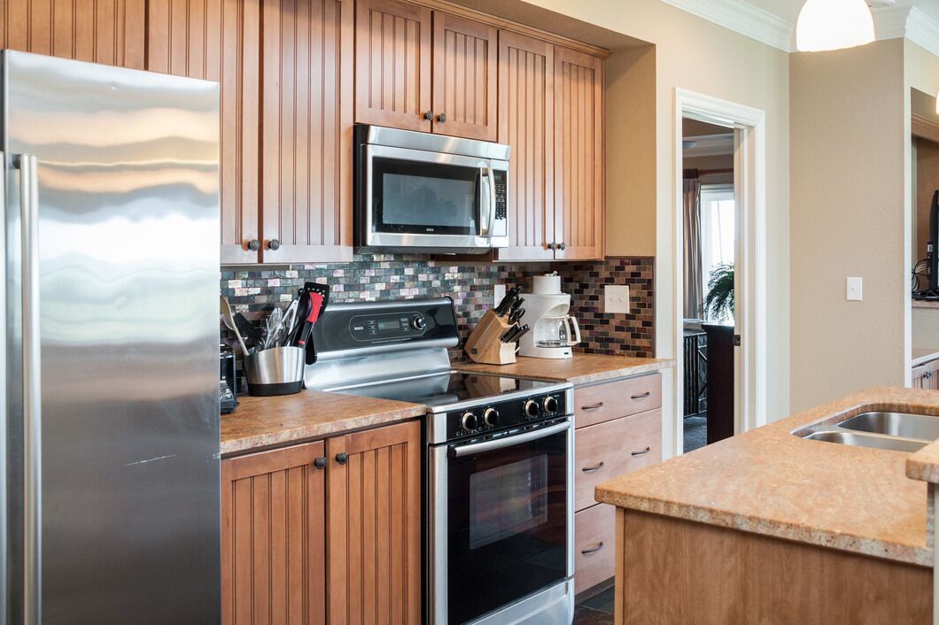 A kitchen with wooden cabinets, stainless steel appliances, a microwave, a stove, and a coffee maker.