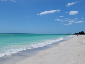 Uma praia com águas turquesa cristalinas e uma faixa de areia.