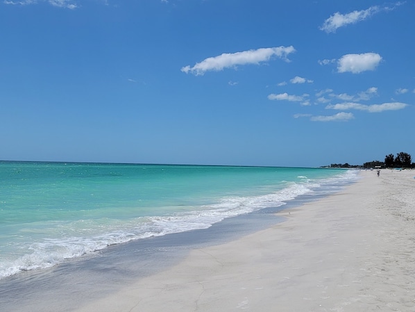 Una playa cerca, sombrillas, toallas de playa