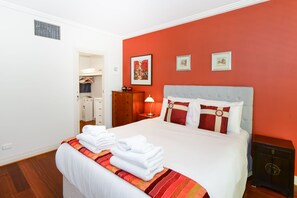 A hotel room with a bed, a nightstand, a dresser, and a wardrobe. - Stylish River Boulevard Apartment in Richmond (Richmond)