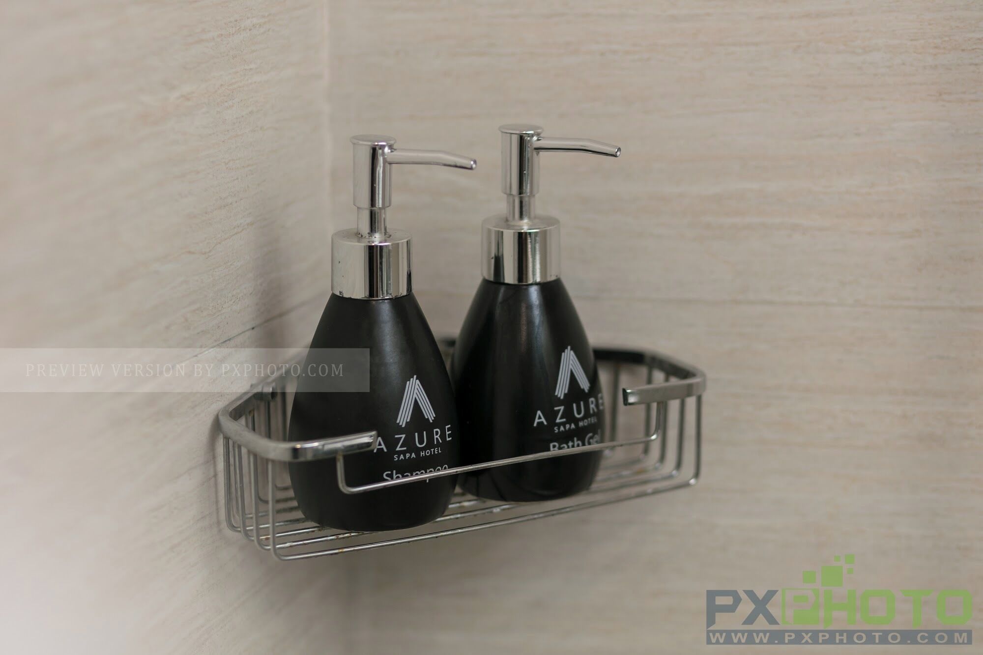 Two black shampoo bottles with pump dispensers on a metal shelf.
