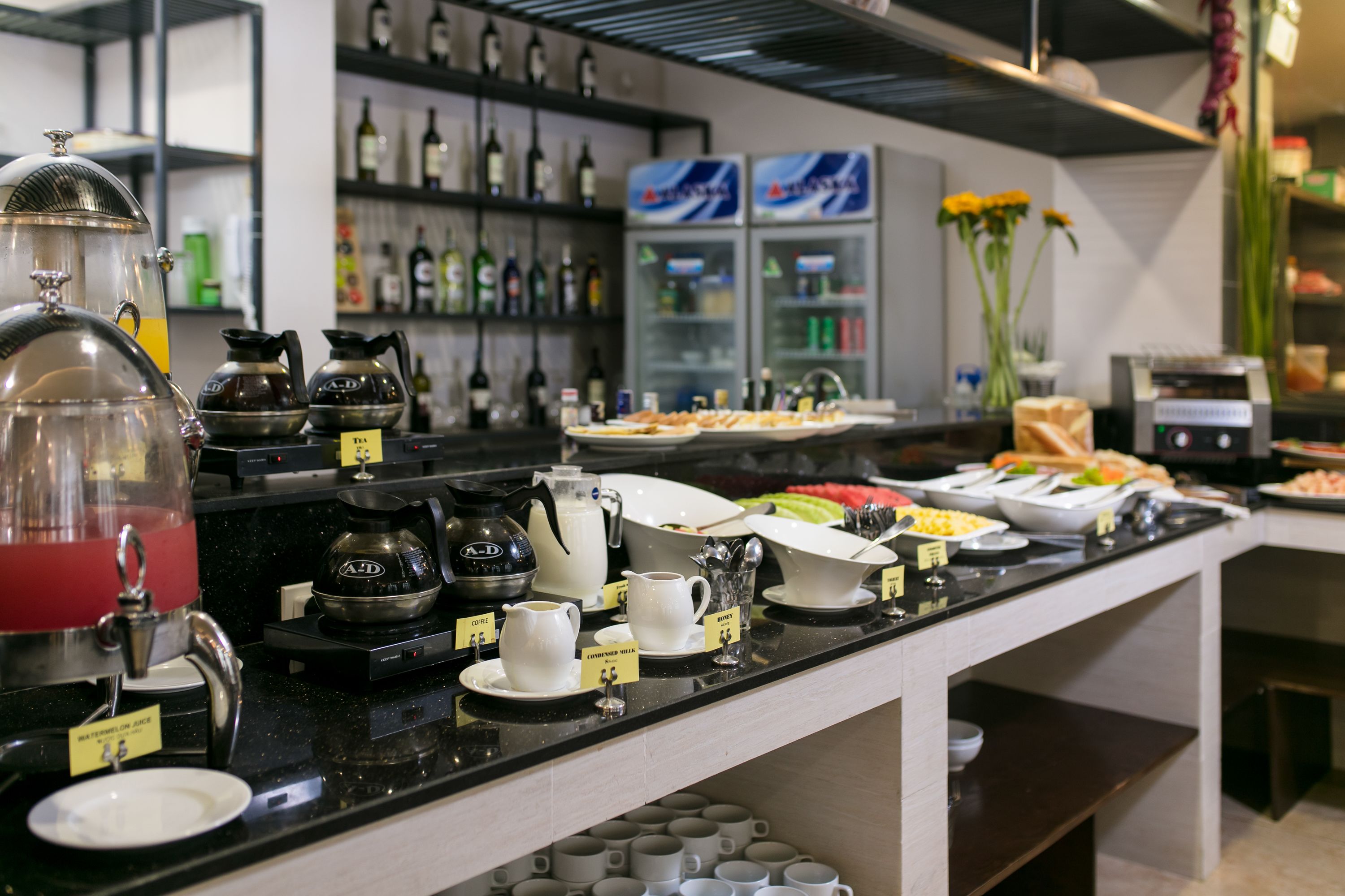 A buffet setup with various food items and coffee brewing equipment.