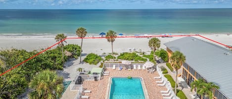 A resort with a swimming pool, beach, and ocean view.