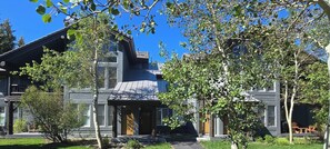 A two-story house with a dark exterior, a front porch, and a small garden area. - Snowcreek Resort Vacation Rental 858 (Mammoth Lakes)