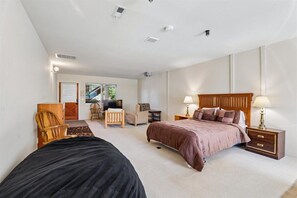 Une chambre à coucher comprenant un lit, des tables de chevet, un bureau et une chaise.