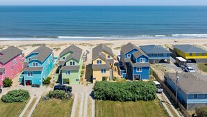Una zona residencial costera con casas coloridas, una playa y una vista despejada del océano.