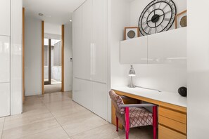 A modern interior with a desk, chair, and a wall-mounted clock. - The Residence Pet Friendly Retreat Dendy Victoria (Brighton)
