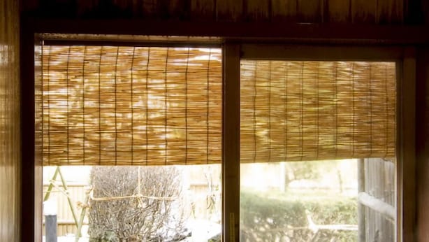 Un onsen japonés tradicional con interior de madera y vistas a un jardín a través de un puertas correderas.