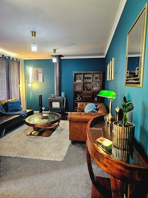 A living room with a sofa, a coffee table, a fireplace, and a bookshelf.