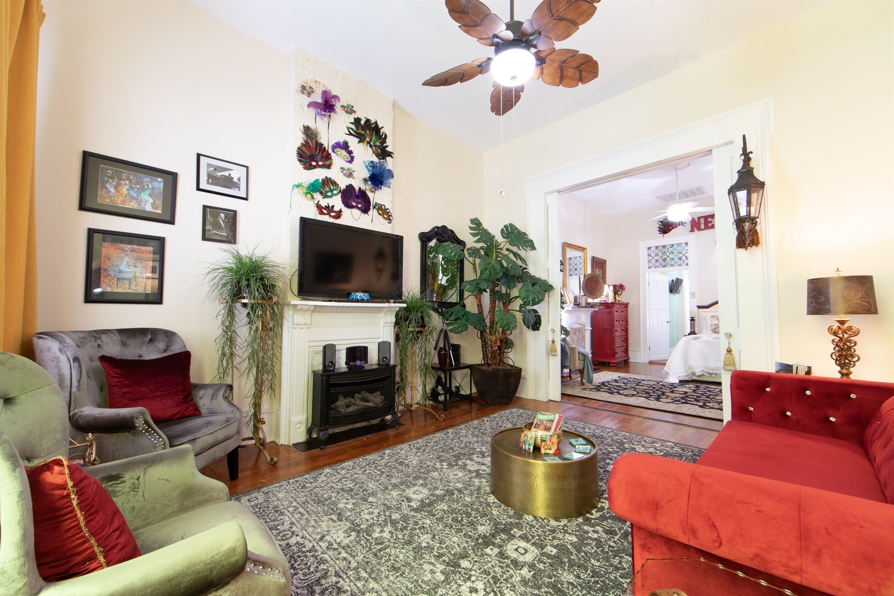 A living room with a fireplace, a television, and various decorative items.