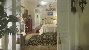 Un dormitorio con una cama, una mesita de noche, una lámpara y un letrero en la pared que dice "New Orleans".
