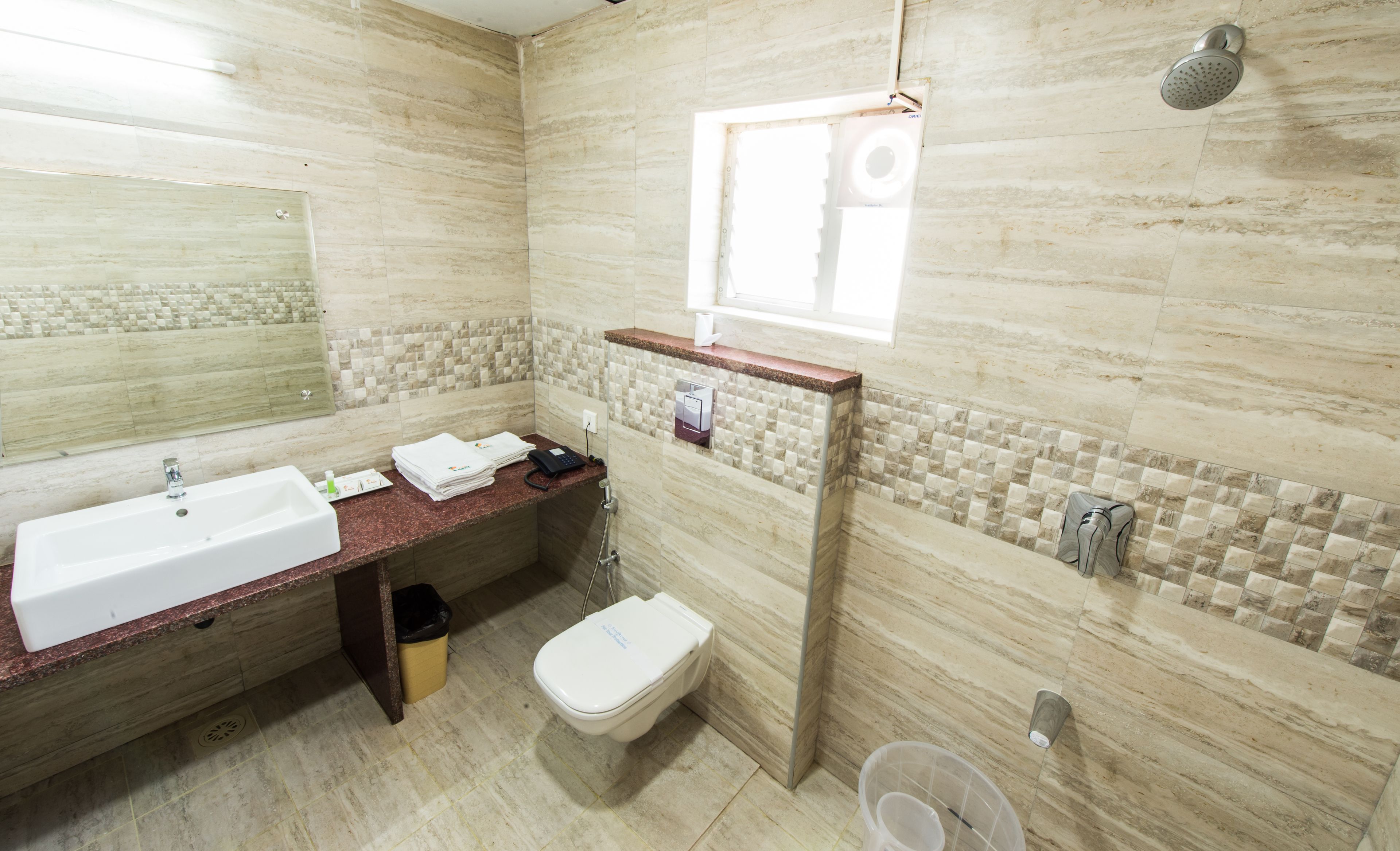 Un baño con lavamanos, espejo, inodoro y ducha.