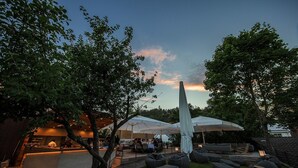 Un espace de restauration en plein air avec des tables et des chaises, un bar et un grand parasol.