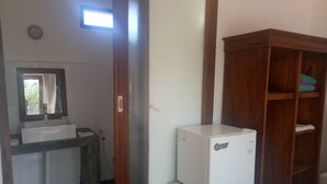 A bathroom with a white sink, a mirror, and a wooden cabinet. - Palm Trees Villas (Gili Air)