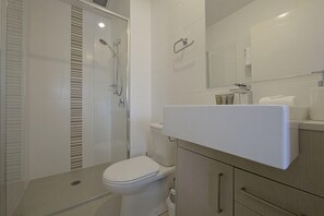 Un baño moderno con inodoro, ducha e lavabo.