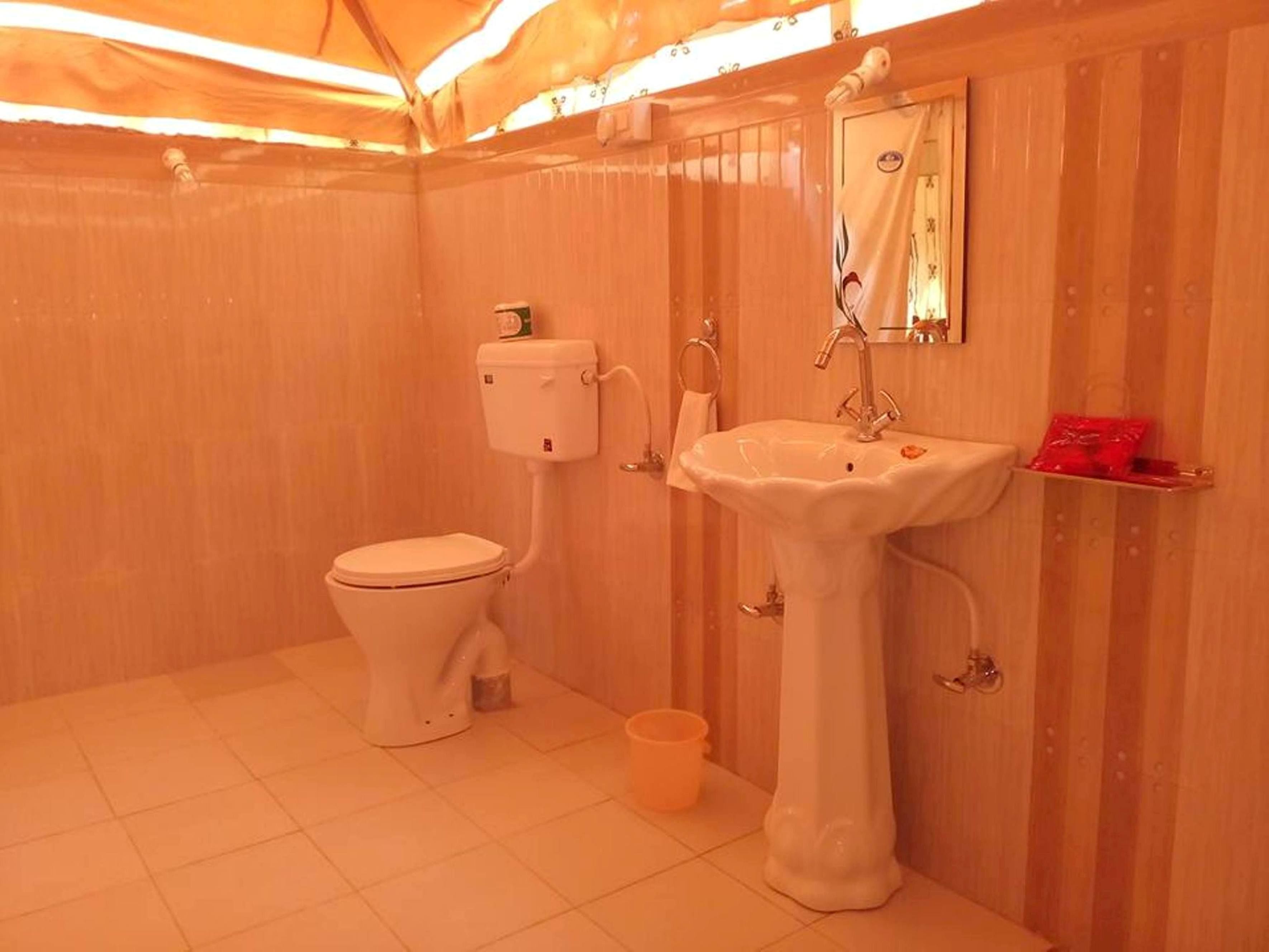 A small bathroom with a toilet, sink, and mirror.