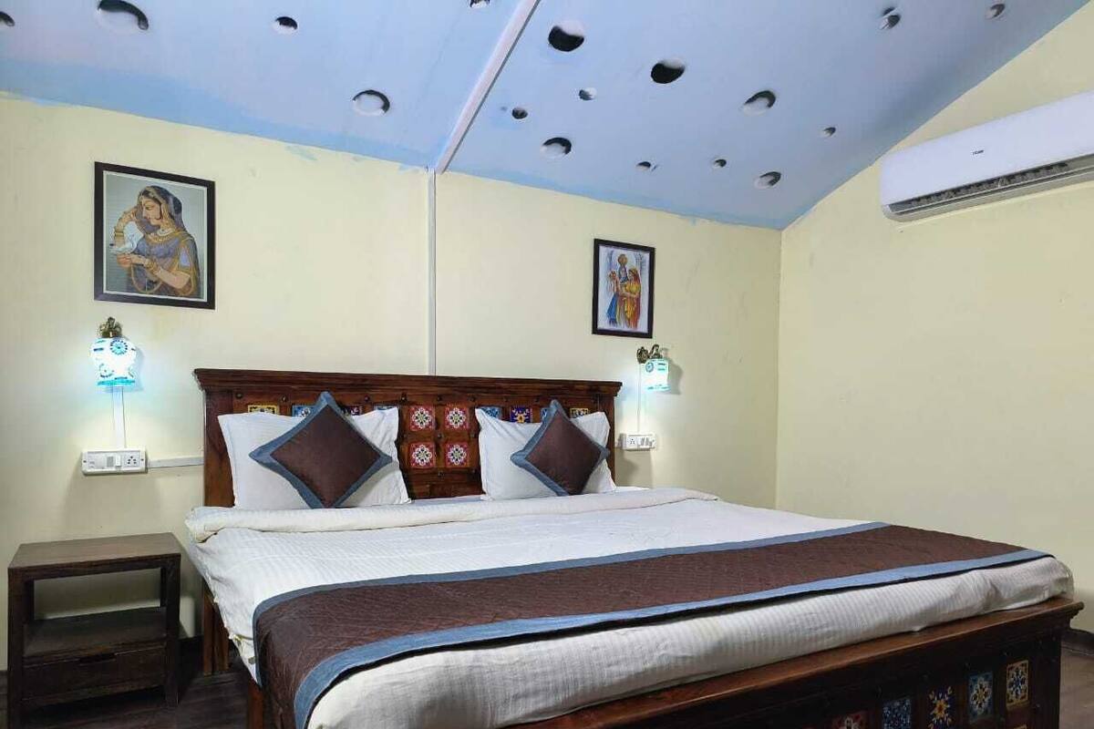 A bedroom with a wooden bed, two wall-mounted lamps, and a ceiling with decorative holes.