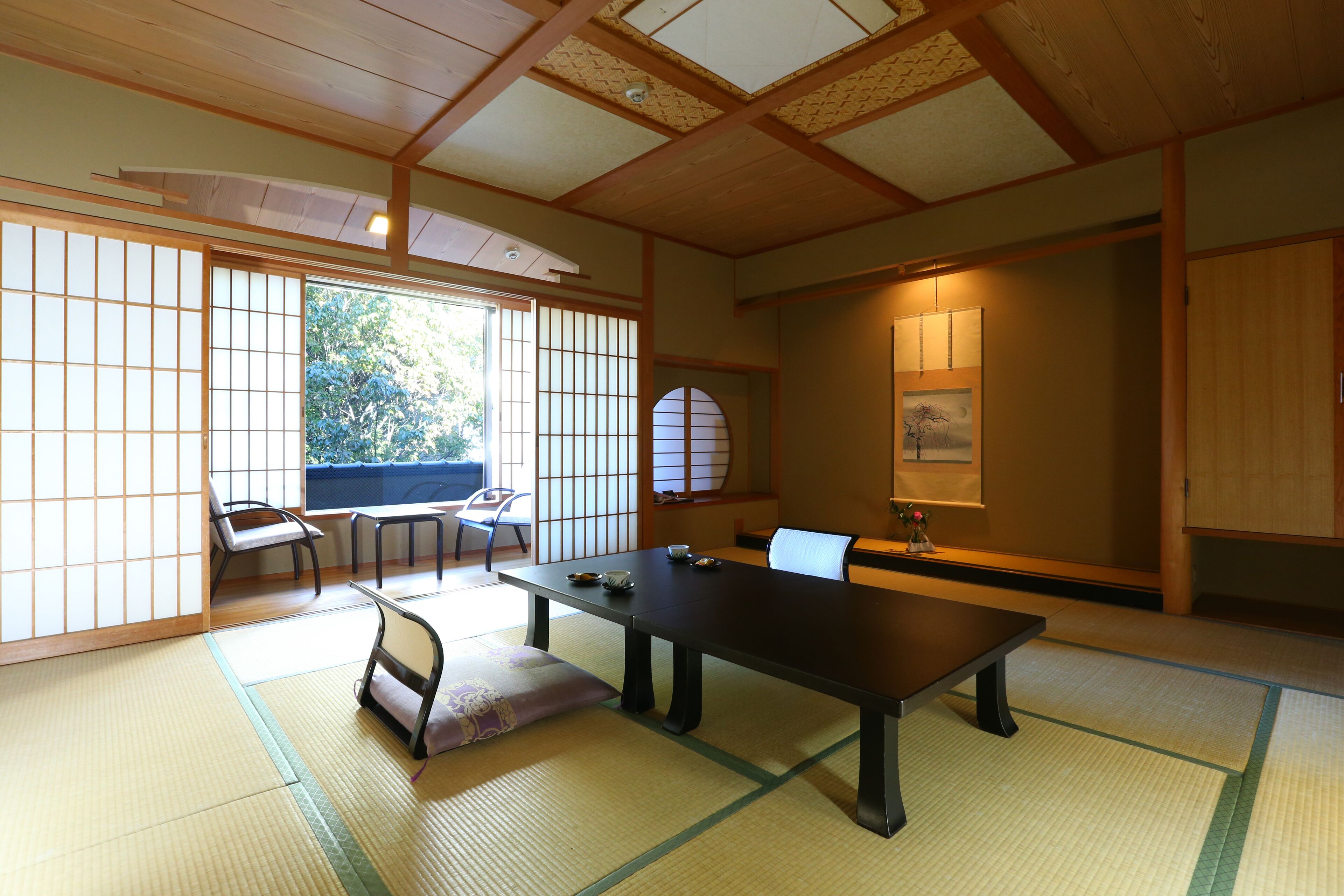 A traditional Japanese room with tatami flooring, a low table, and sliding doors.