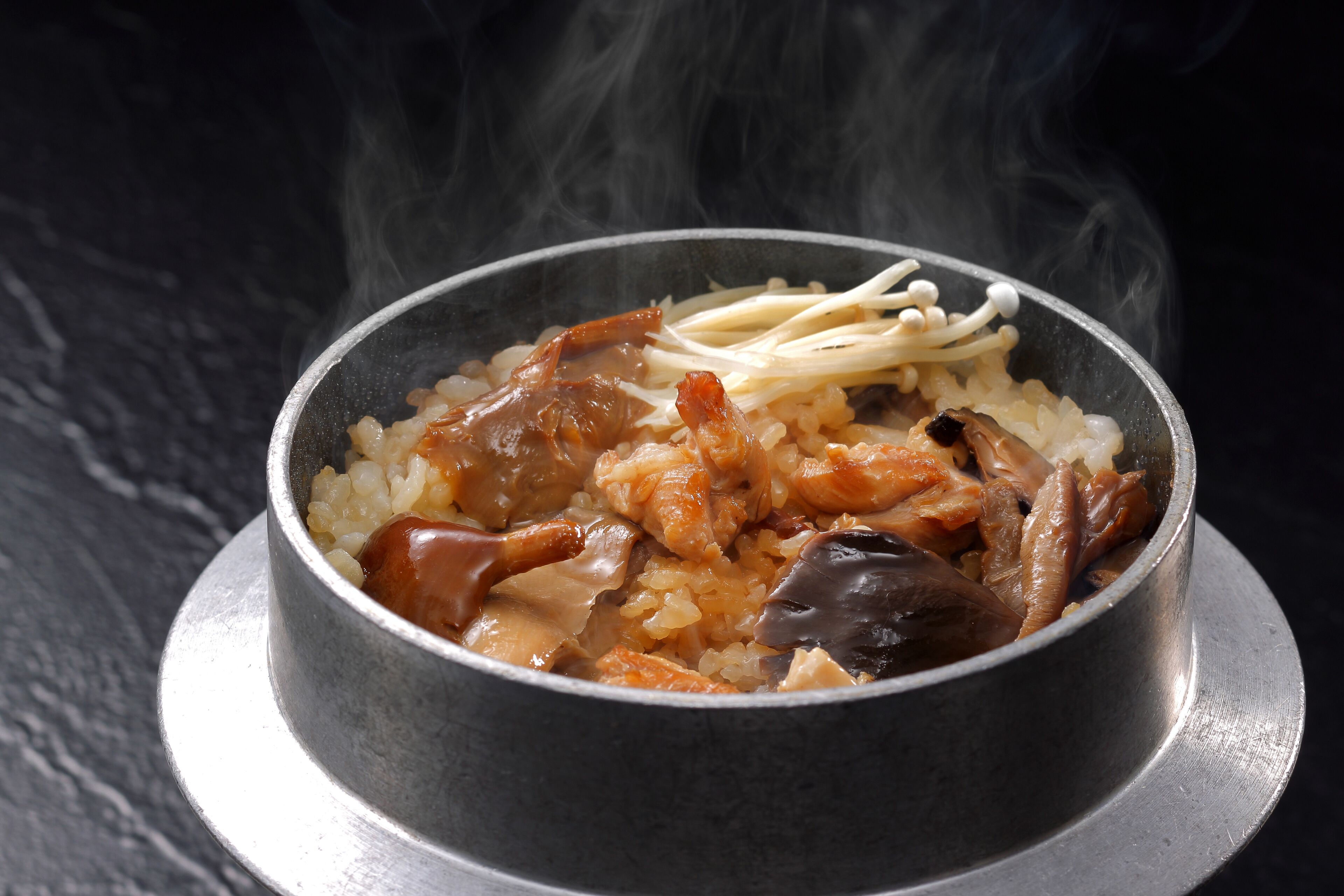 Un plato de comida con arroz, carne y champiñones.