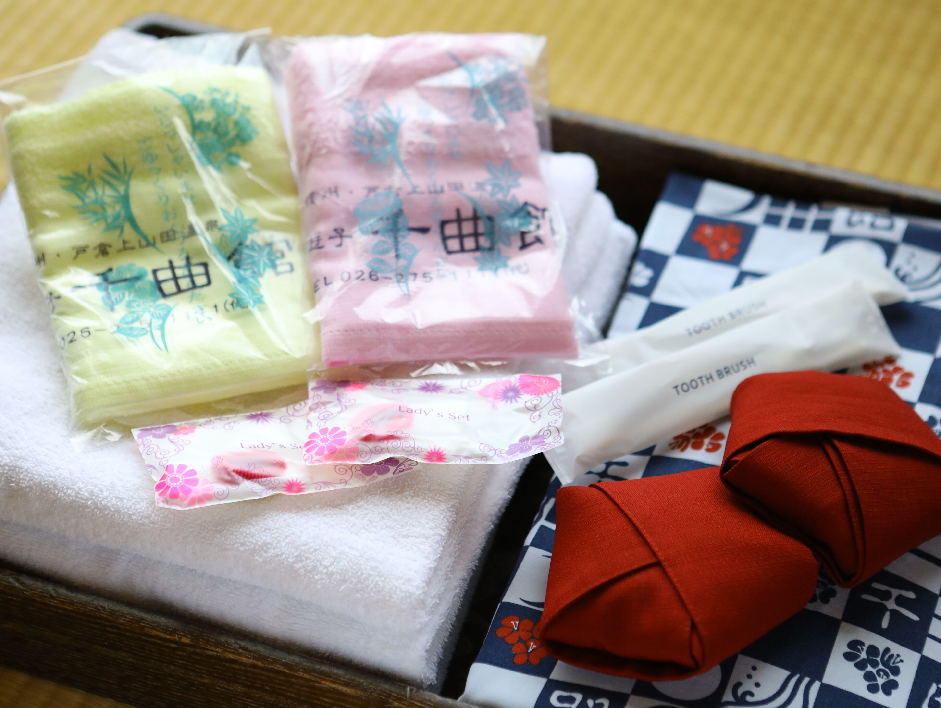 A tray with various items including a toothbrush, a red cloth, and several packages with floral designs.