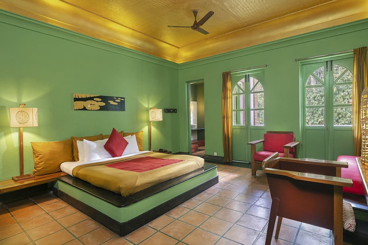 A room with a bed, a chair, a desk, and a window.