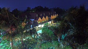 A hotel with a unique architectural design featuring a series of triangular structures and a bridge connecting different levels. - Mango Hill Pondicherry (Vanur)