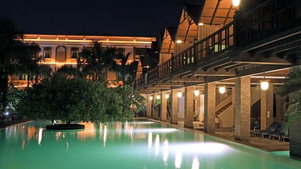 A swimming pool with a view of a building with a balcony and a staircase. - Mango Hill Pondicherry (Vanur)