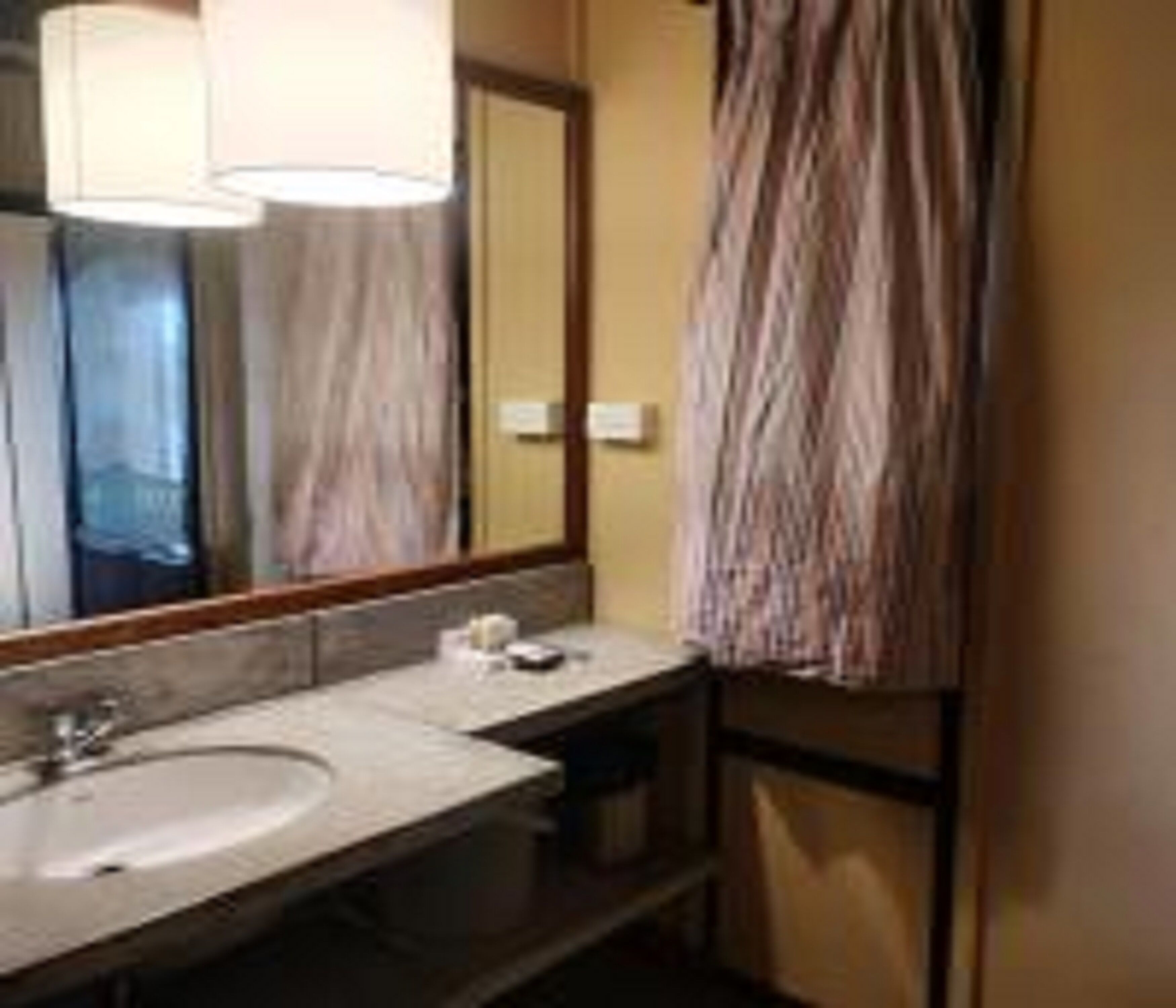 A bathroom with a sink, mirror, and towel rack.