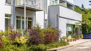 A modern building with a balcony, large windows, and a sign that reads "Reception". - Ośrodek Wypoczynkowy Wiga (Kolobrzeg)