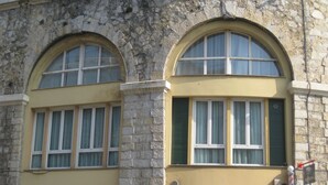 A building with two arched windows and a storefront labeled "Barberia Italiana". - Midnight in Genova (Genoa)