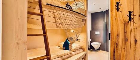 A bunk bed with a net canopy, a ladder, and a blue pillow.