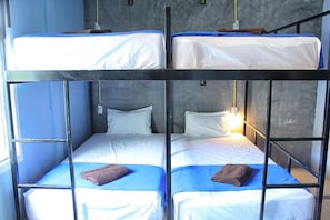 A bunk bed room with four beds, each with a pillow and a blanket. - Phangan Guest House - Hostel (Ko Pha-ngan)