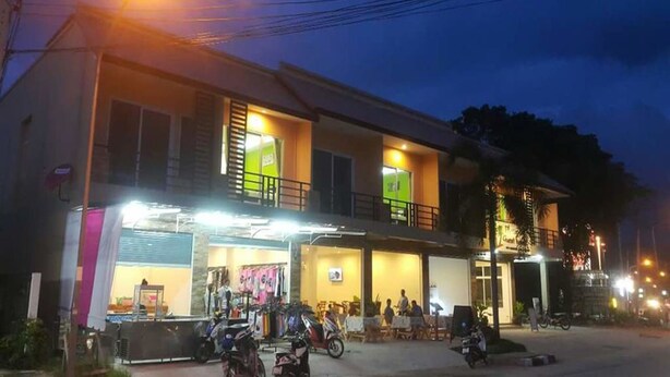 Un edificio de dos pisos con una tienda en la planta baja y un balcón en el piso superior.