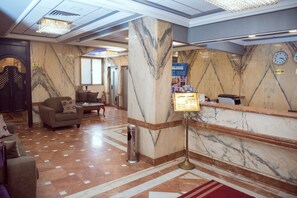 Welcome to our lobby, featuring a reception desk, comfortable seating, and a convenient signboard.